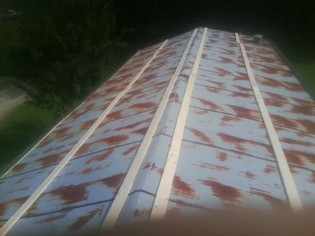 Rusted metal roof panels with new wood purlins before replacement — Storm Damage Roof Repair in Jarratt by Roofing Brothers